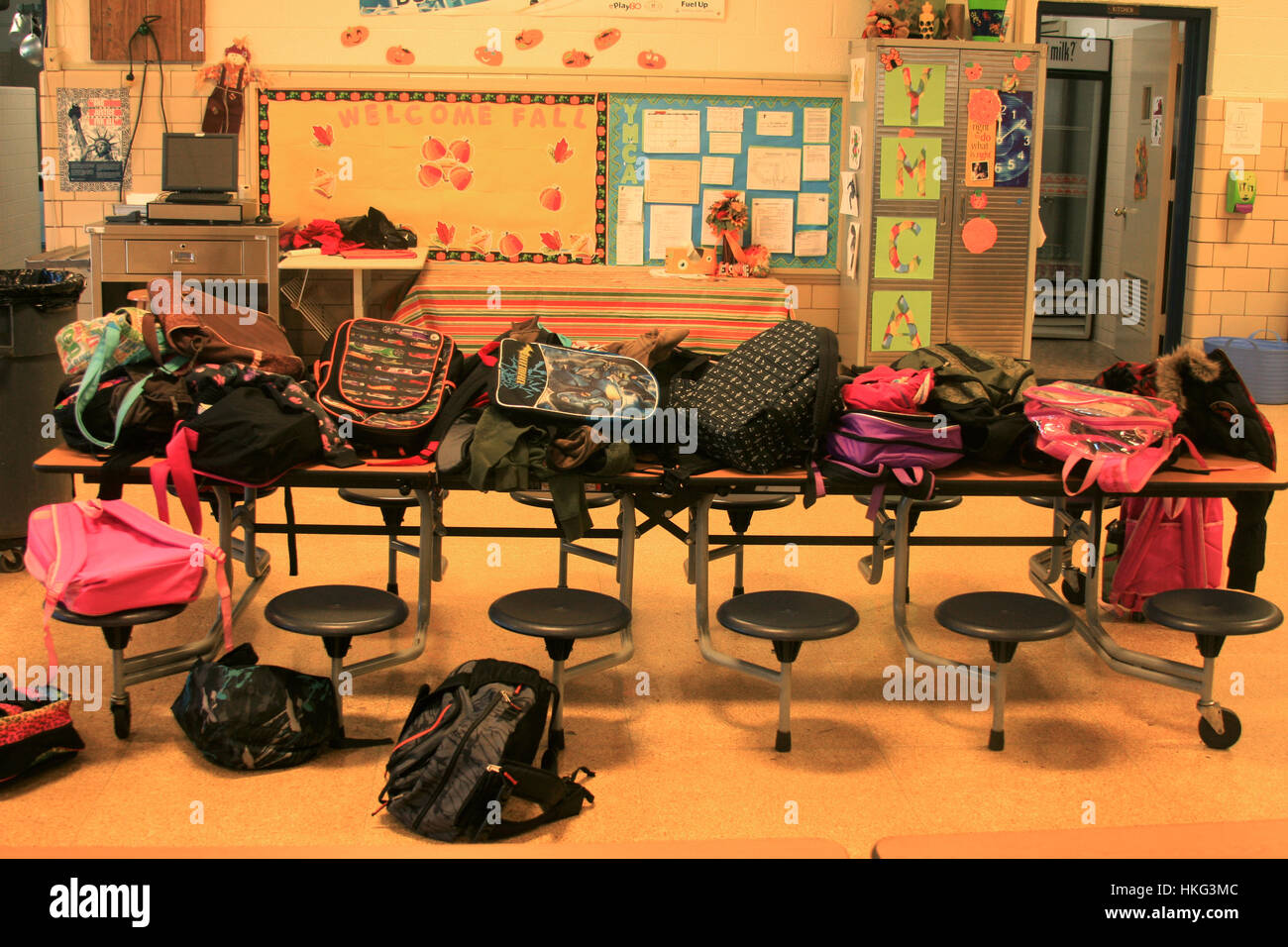 Backpacks piled on top of desks in public school U S A Stock Photo Alamy