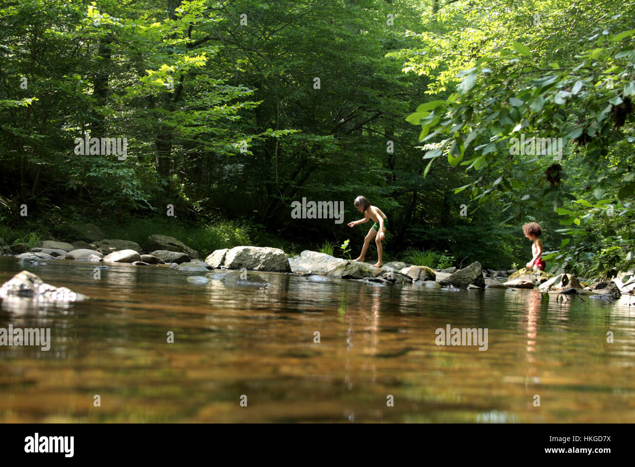 Children playing in mountain creek in hot summer day Stock Photo