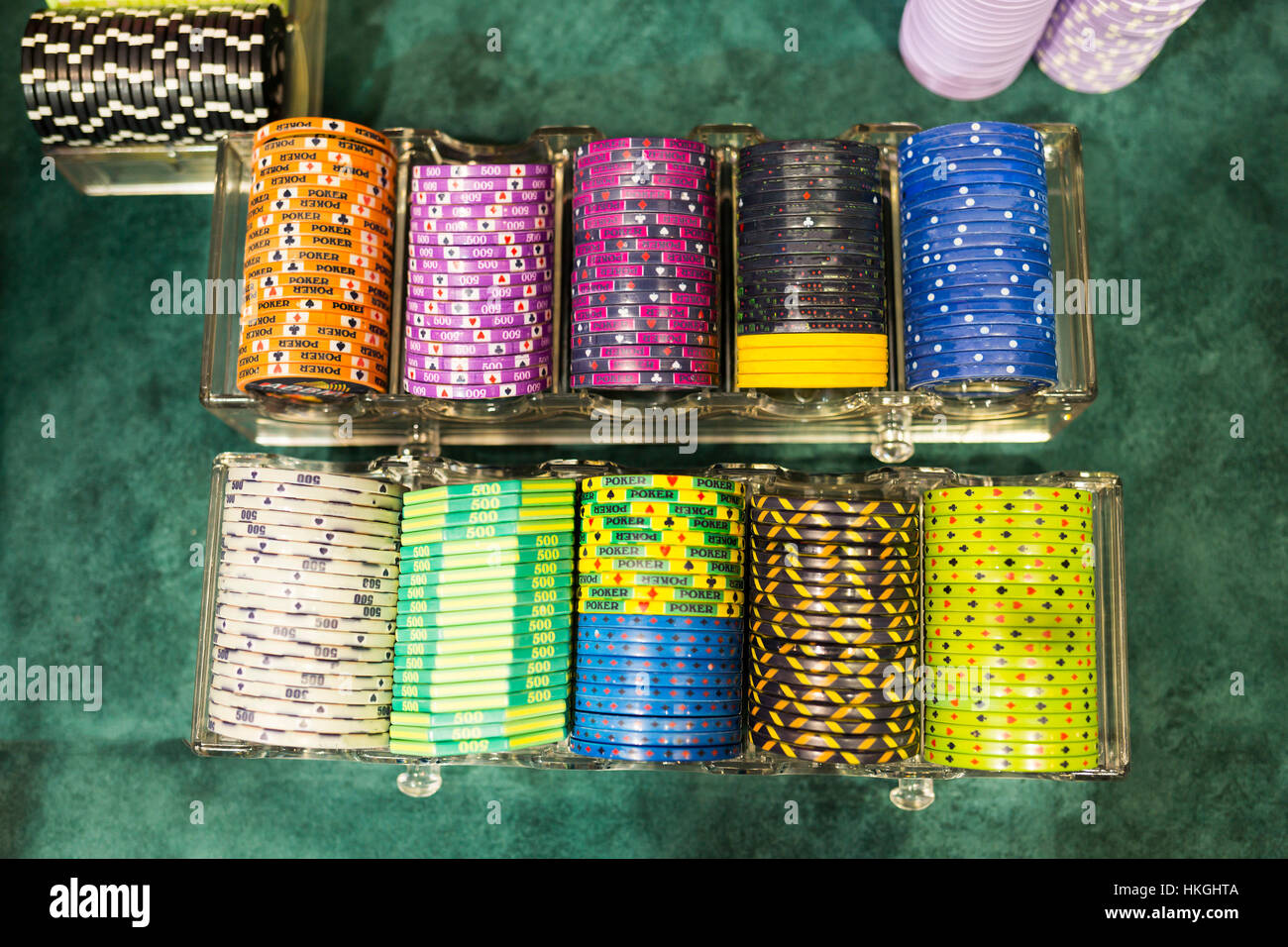 Colourful poker chips in a casino on a gambling table. Lots of chips with different nomination and colours. Stock Photo