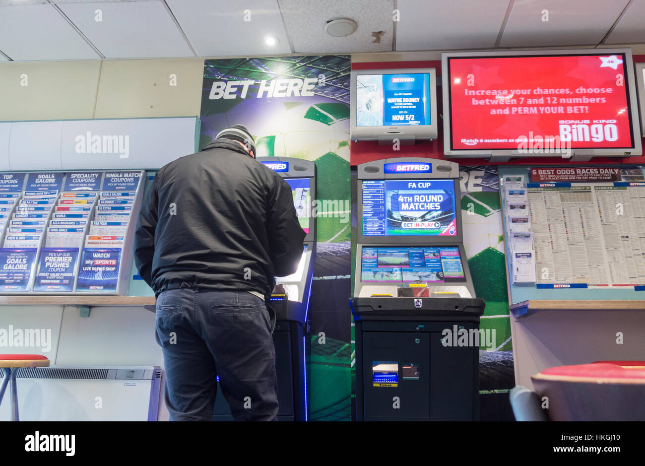 Man using gaming machine in Betfred bookmakers. UK Stock Photo