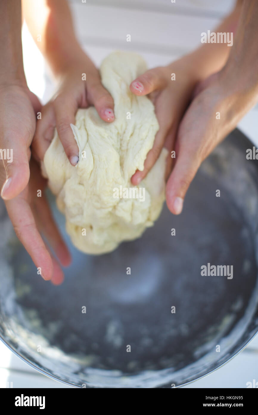 hands kneading dough. flour, homemade, helping hands, food. Stock Photo