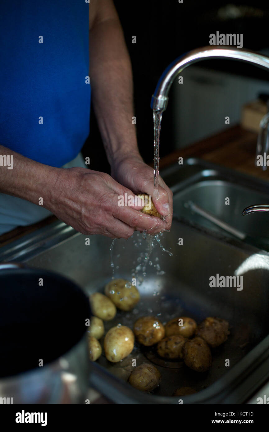 hands washing potatoes in kitchen. running water, rinse, sink, food