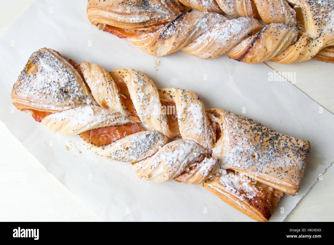 Braided sweet puff pastry sprinkled with poppy seeds Stock Photo