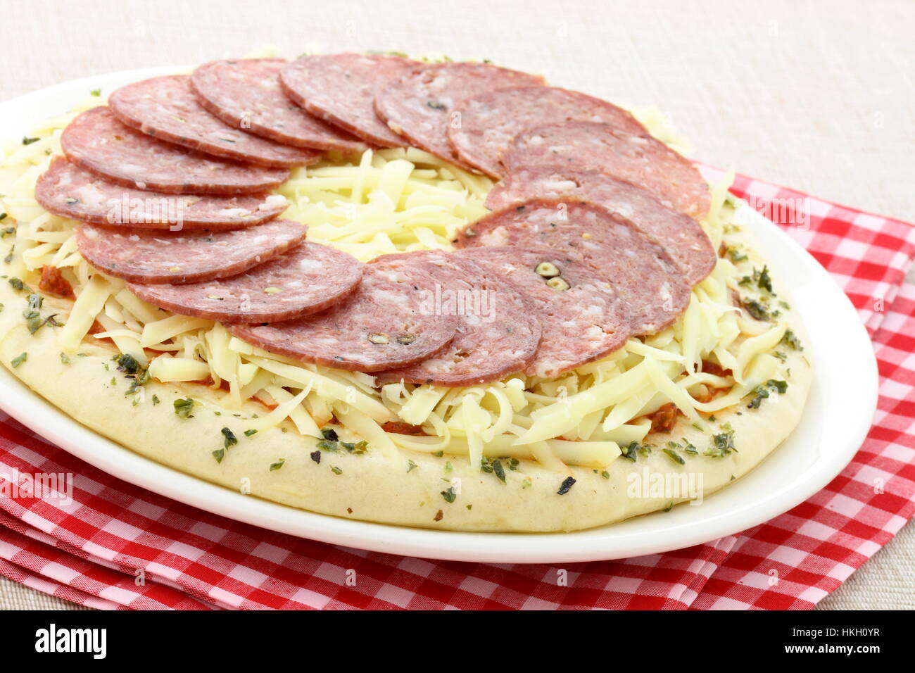 ready to bake delicious rustic salami and cheese pizza Stock Photo - Alamy