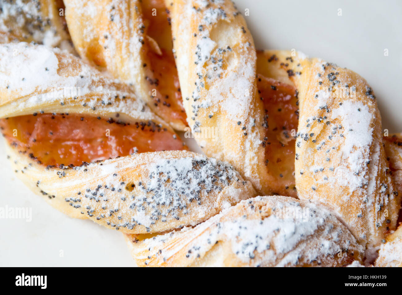 Close up of braided sweet puff pastry with poppy seeds Stock Photo