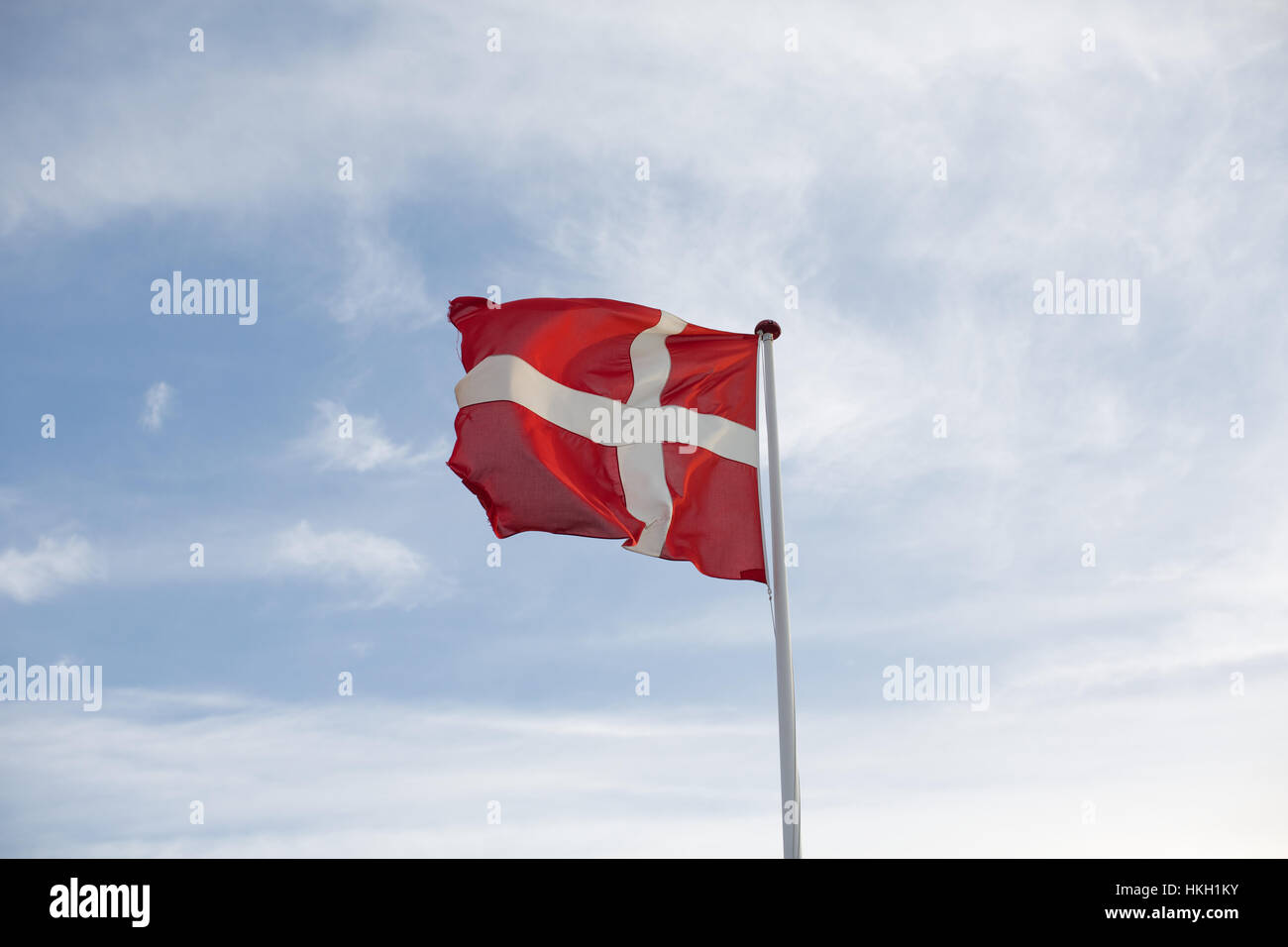 fluttering danish flag and cloudy sky. flagpole, patriotism, national flag, denmark. Stock Photo