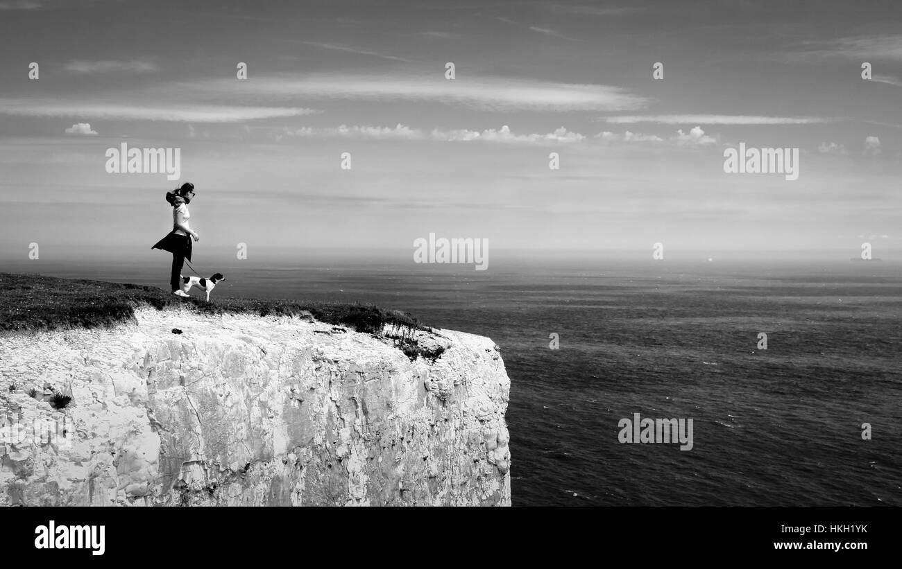 Girl and dog taking in the view of France over the English Channel from high atop the White Cliffs of Dover Stock Photo