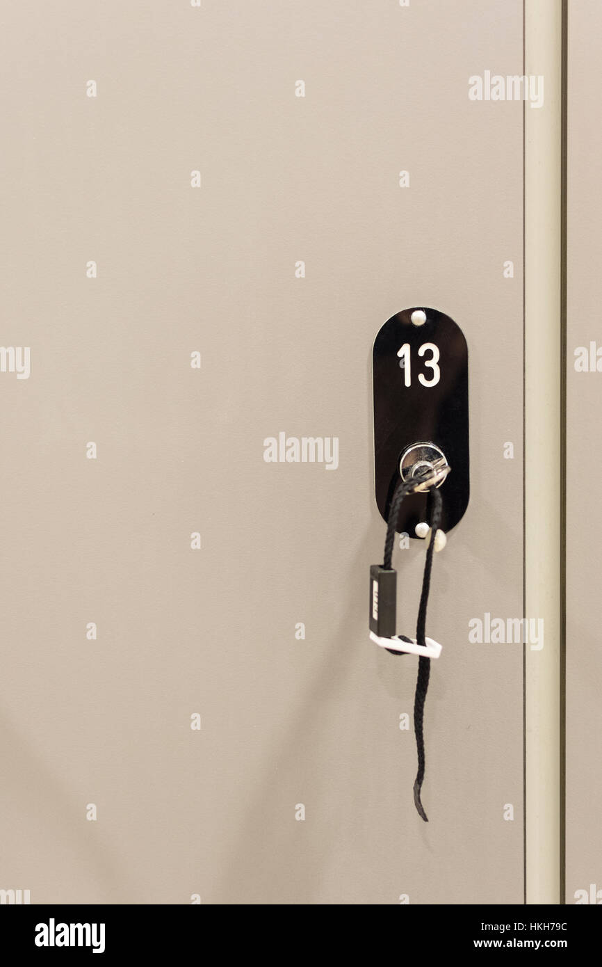 Grey Cabinets with Numbered Locks and Keys in School, Gym or Locker Room Stock Photo