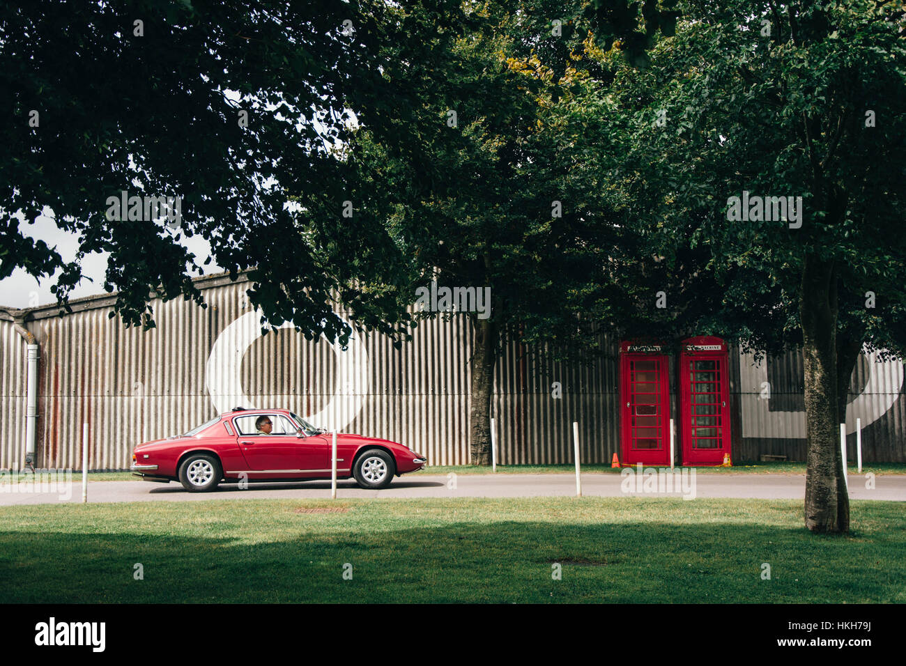 Older man driving a classic red sports car Stock Photo