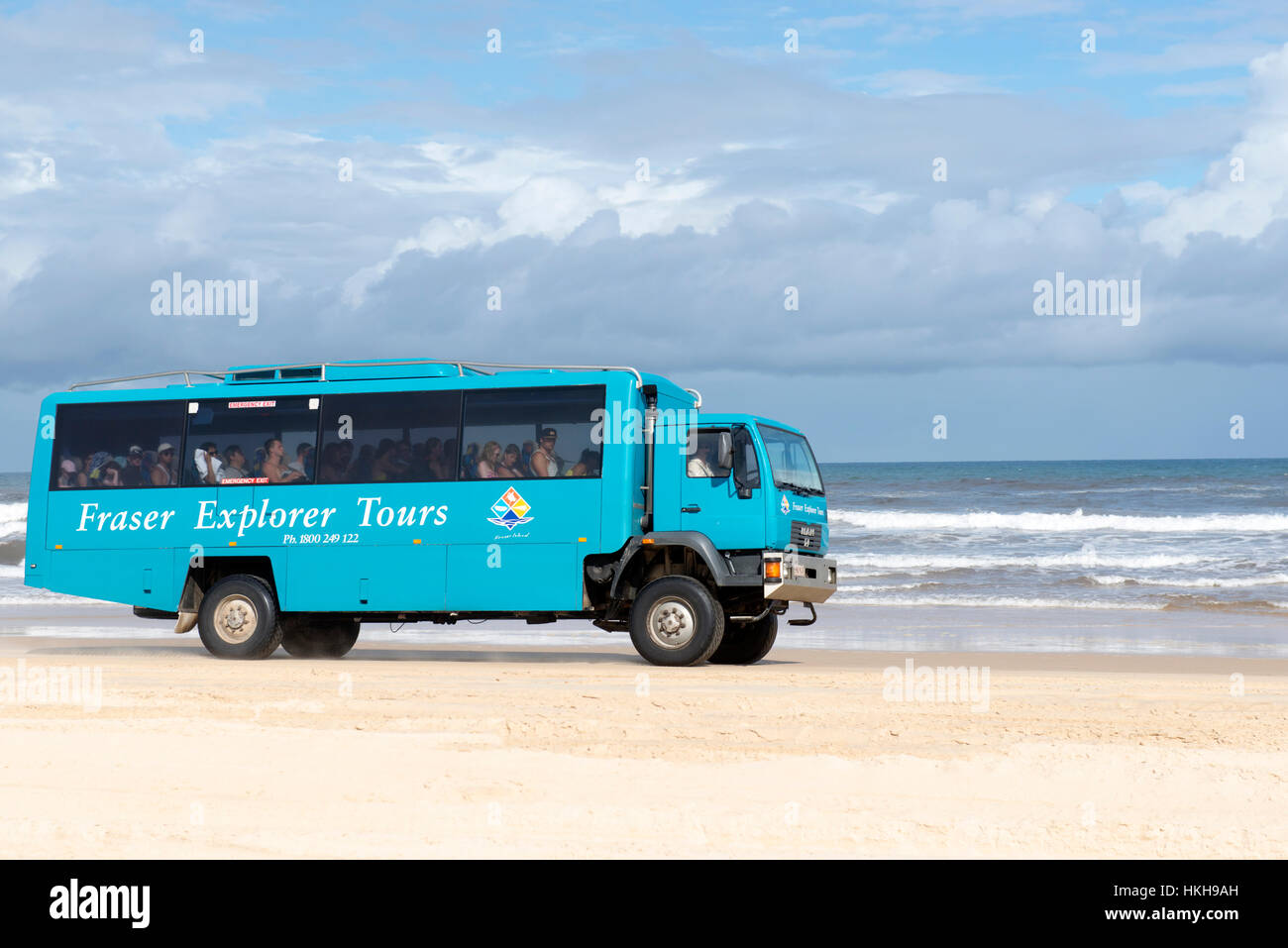 A tour bus driving down 75 Mile Beach on Fraser Island, Queensland Australia Stock Photo