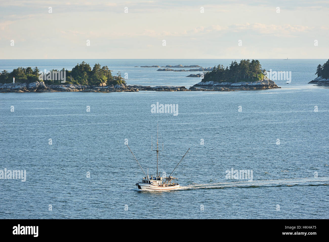 Fishboat moving next to islands and rocks Stock Photo