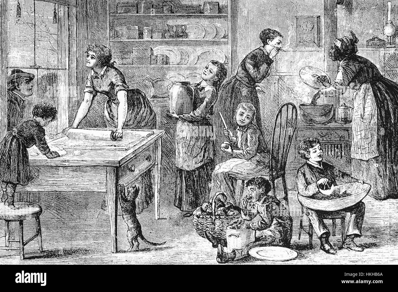 1879: Thanksgiving Day and New York family gather in the kitchen to prepare Thanksgiving Pudding - of which there are a number ranging from Pumpkin to Apple. Stock Photo