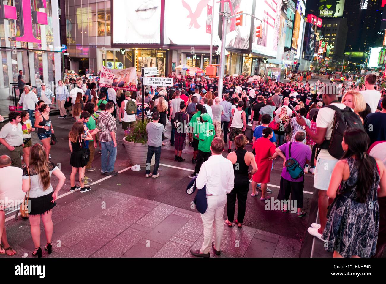 During a Black Lives Matter protest in New York City's Times Square following the shooting deaths of Alton Sterling and Philando Castile, activists block traffic and square off against a line of New York Police Department (NYPD) riot police as tourists look on, 2016. Stock Photo