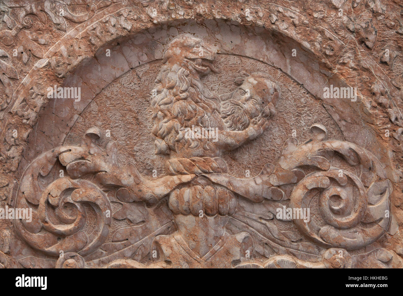 Lion holding a human head. Detail of the tombstone in Saint Peter's Church (Alter Peter) in Munich, Bavaria, Germany. Stock Photo