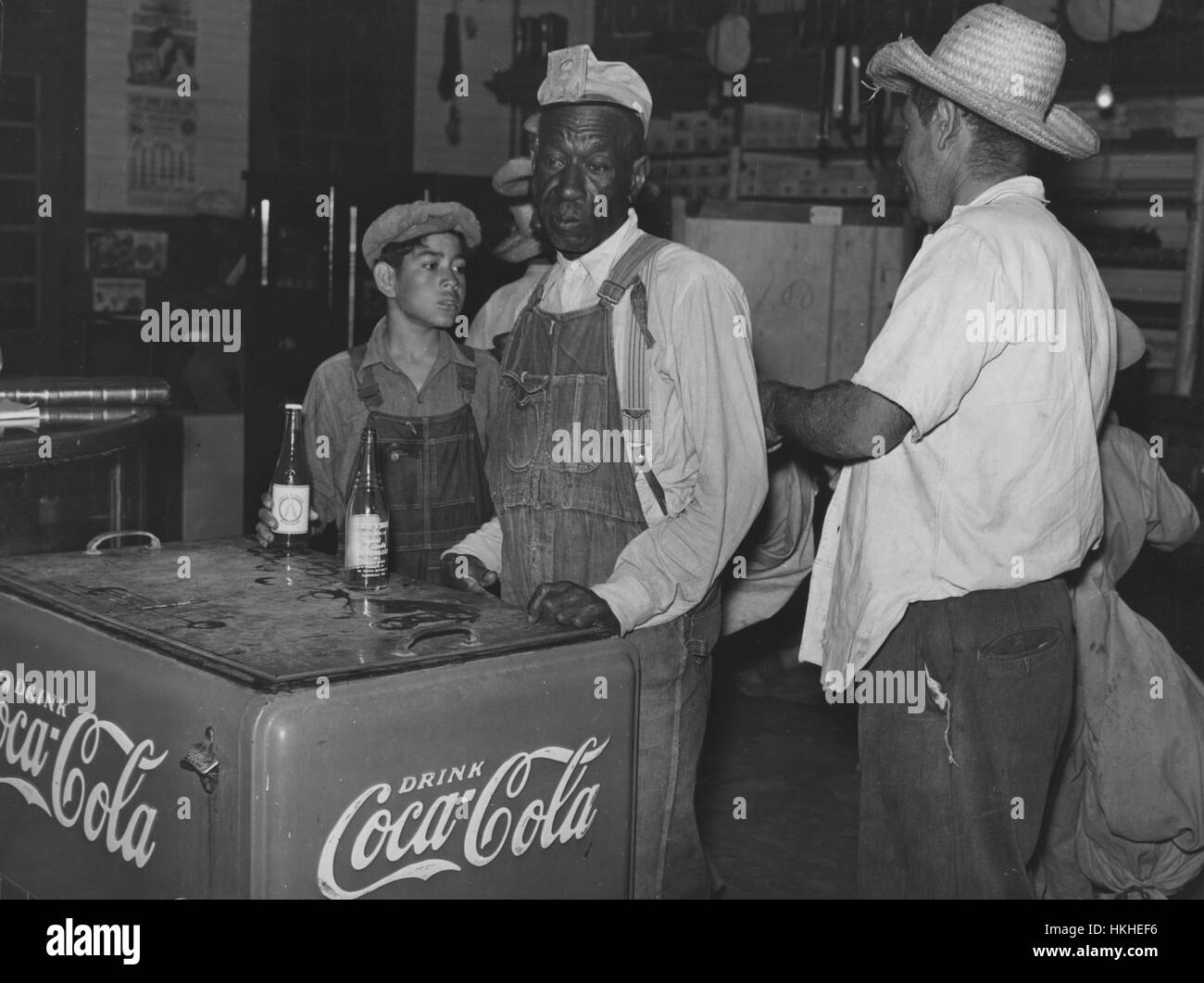 Black and white photograph of Mexican and African-American cotton pickers inside plantation store, Knowlton Plantation, Perthshire, Mississippi Delta, Mississippi, October, 1939. From the New York Public Library. Stock Photo