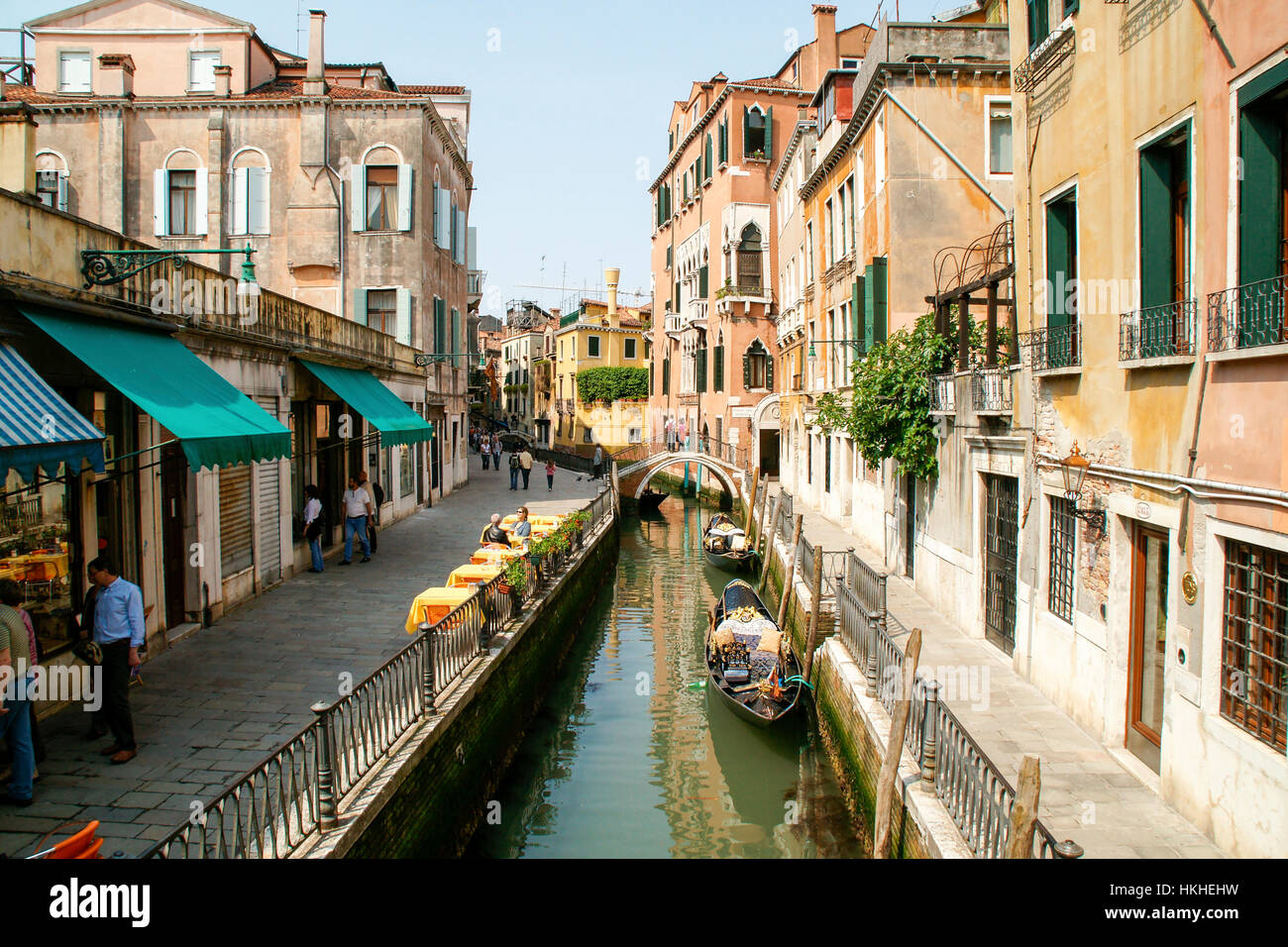 Morning In Venice. Two gondolas ready for the day and people looking in shop windows.  Italy Stock Photo