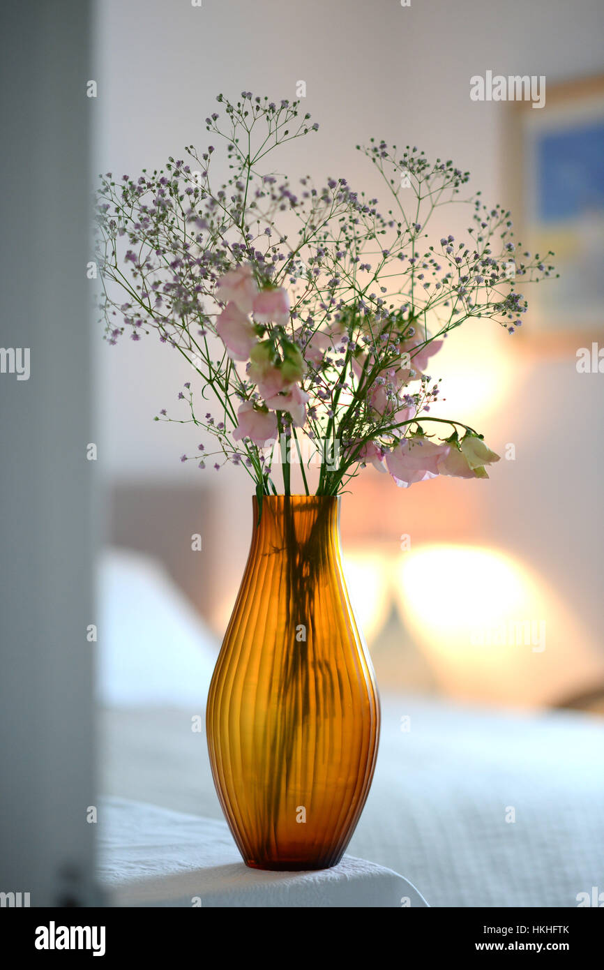 Amber Glass Fluted Vase With Flowers In A Room Stock Photo