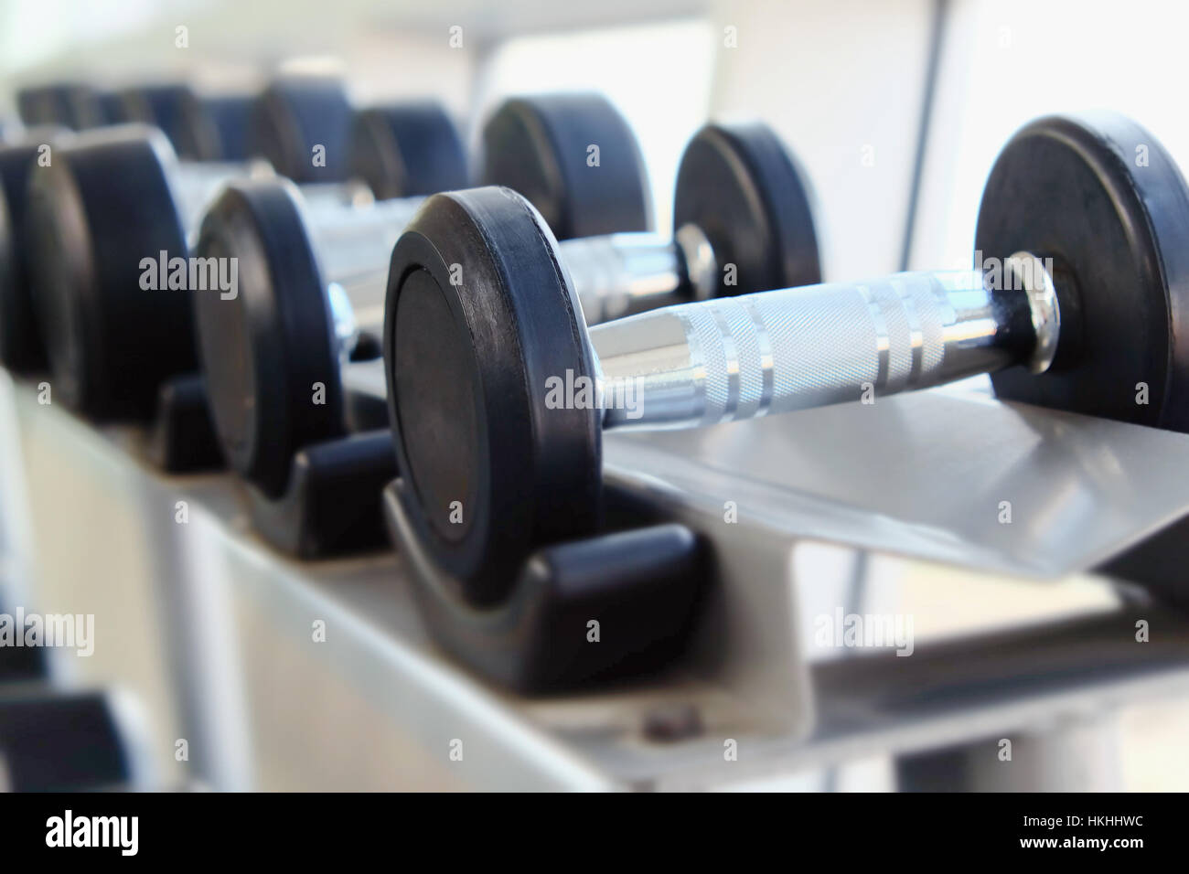 Dumb bells lined up in fitness room Stock Photo