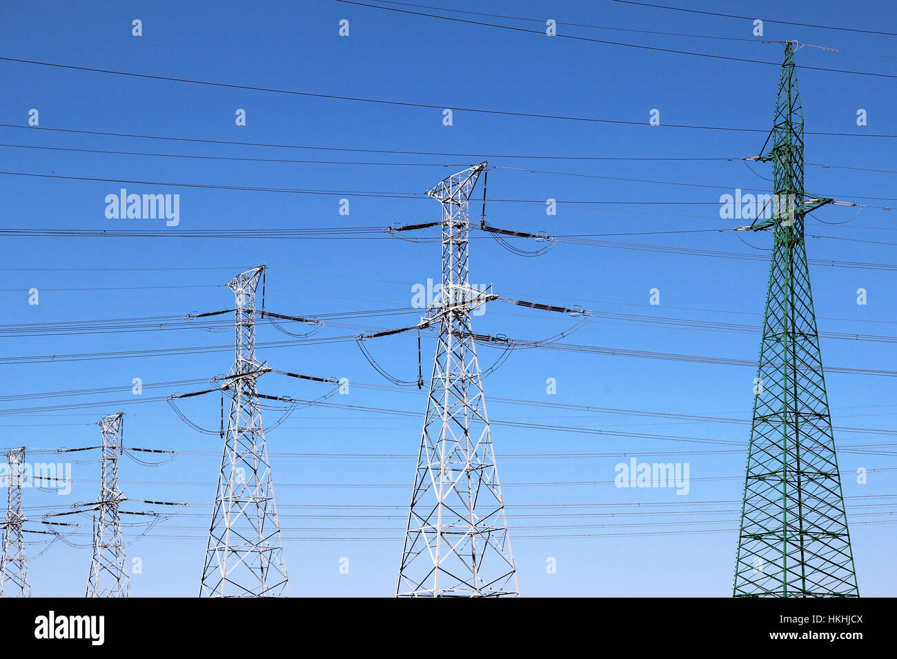 Group of high voltage towers under blue sky Stock Photo - Alamy
