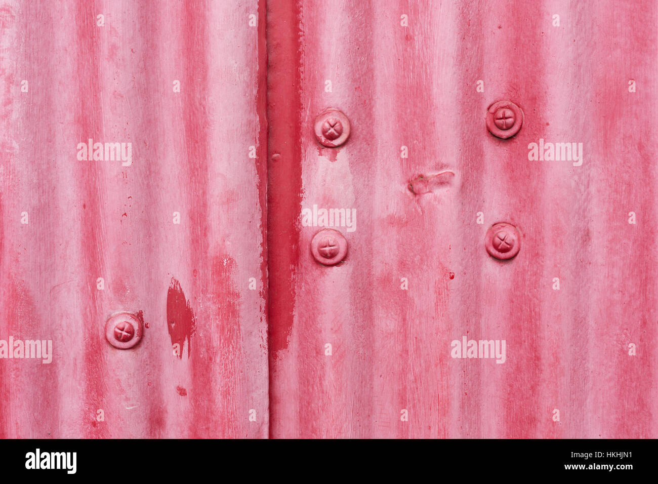 Close up of red painted metal with a corrugated texture and rivets Stock Photo