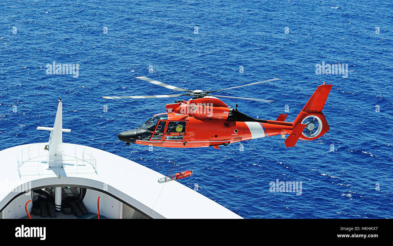 Rescue helicopter next to ship bow in operation Stock Photo