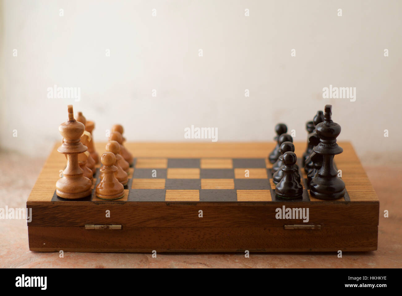 A half chess board with black and white chess pieces arranged facing eachother Stock Photo