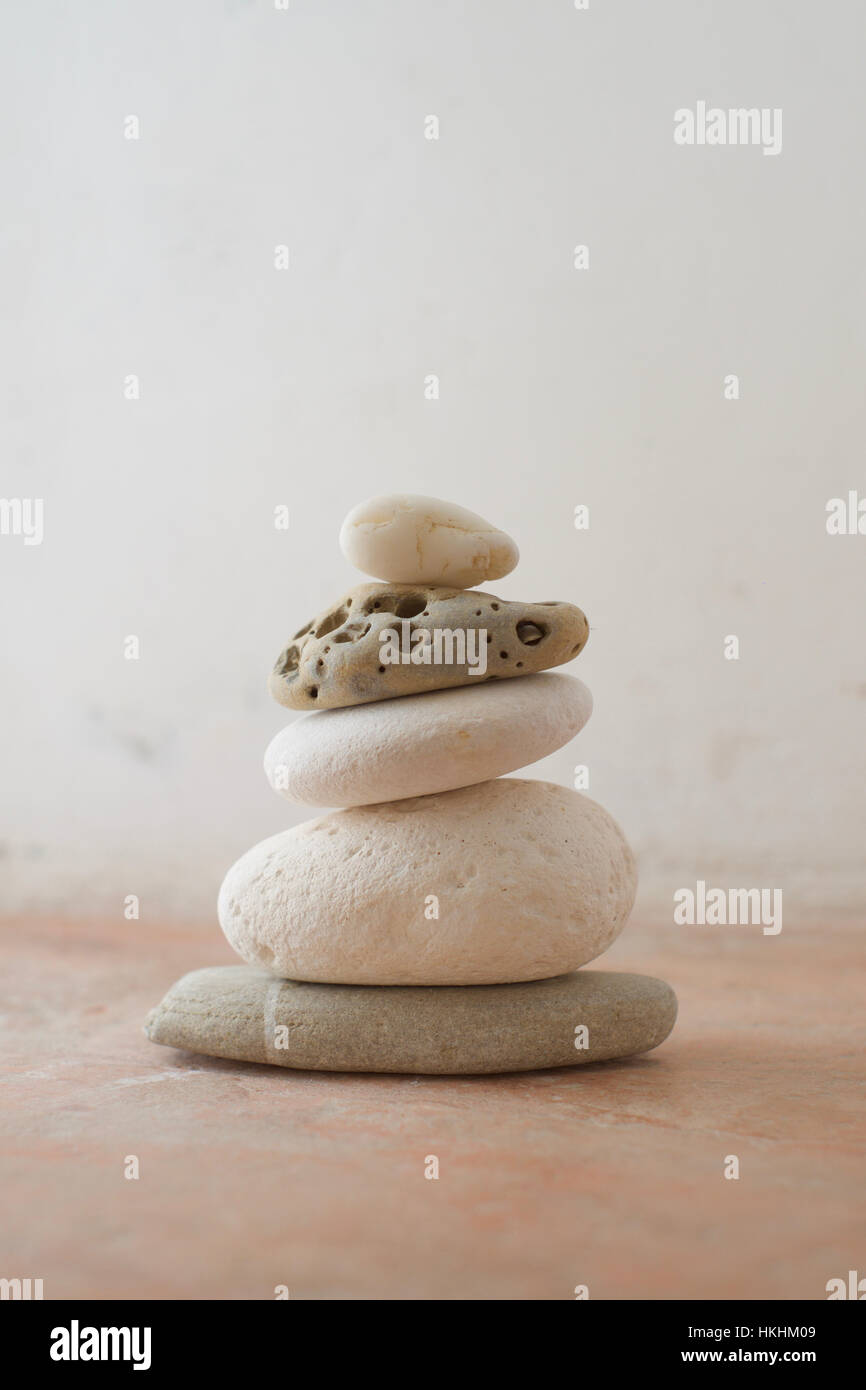 A stack of pebbles with light tones against a rustic background Stock Photo