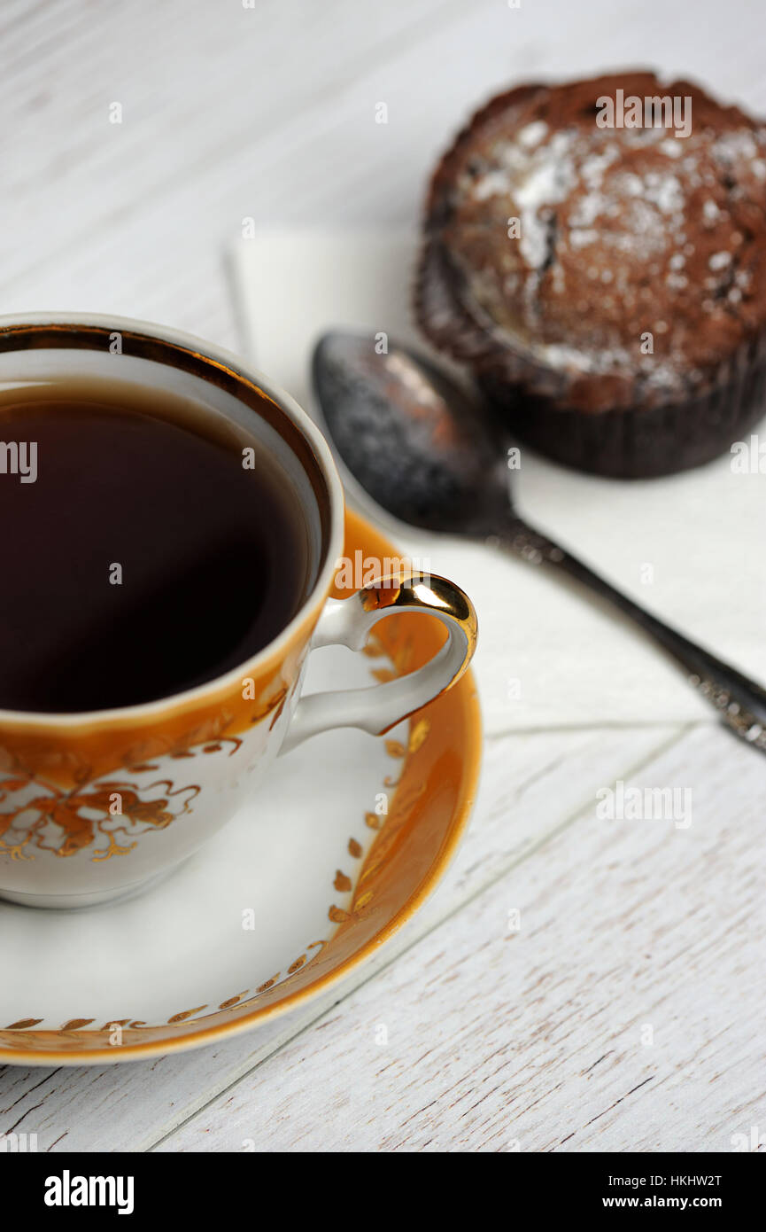 black tea on wood table with cupcake on back Stock Photo