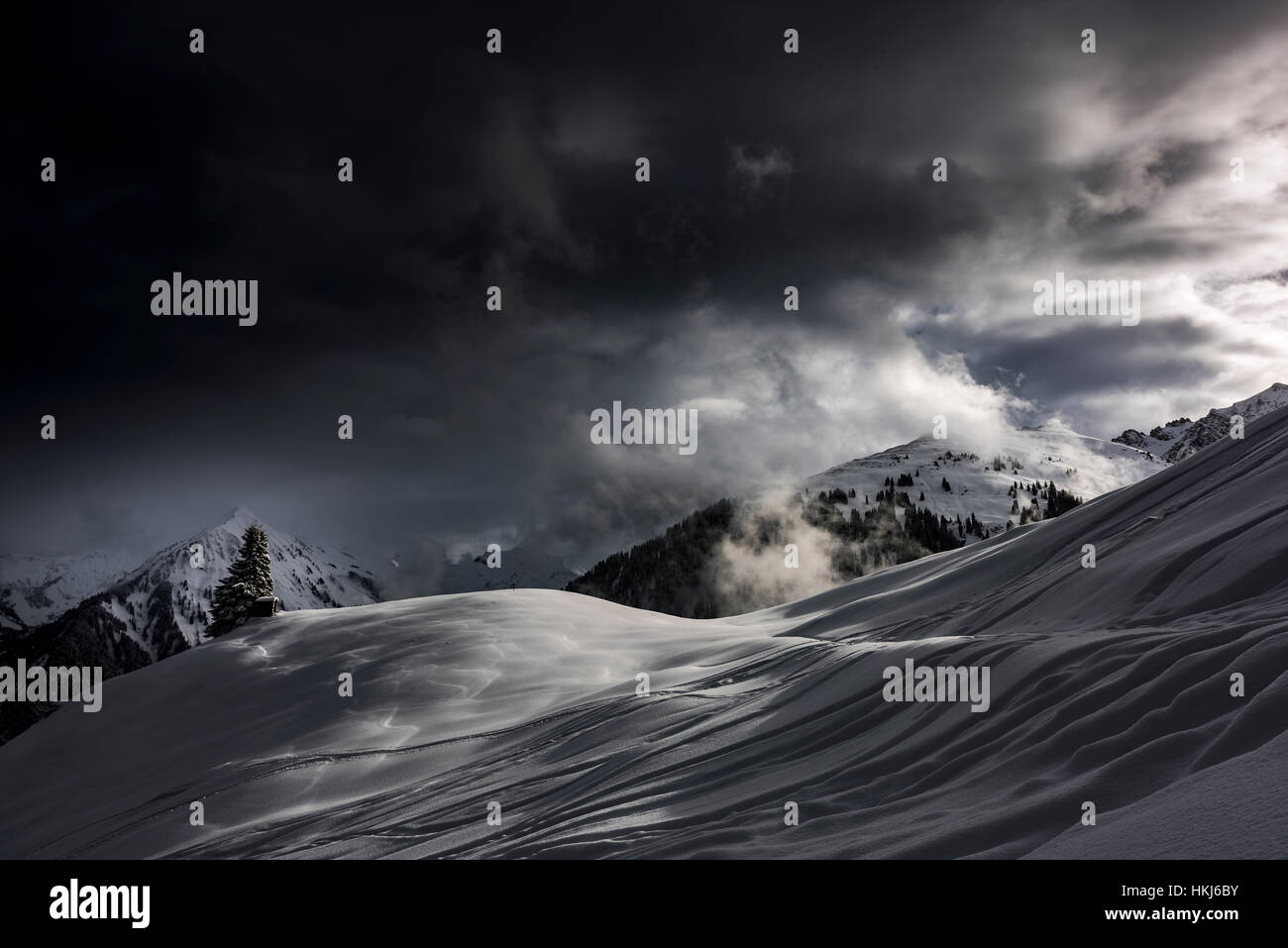 Snowy mountain landscape, dramatic light with dark clouds, Hittisau, Bregenz Forest, Vorarlberg, Austria Stock Photo