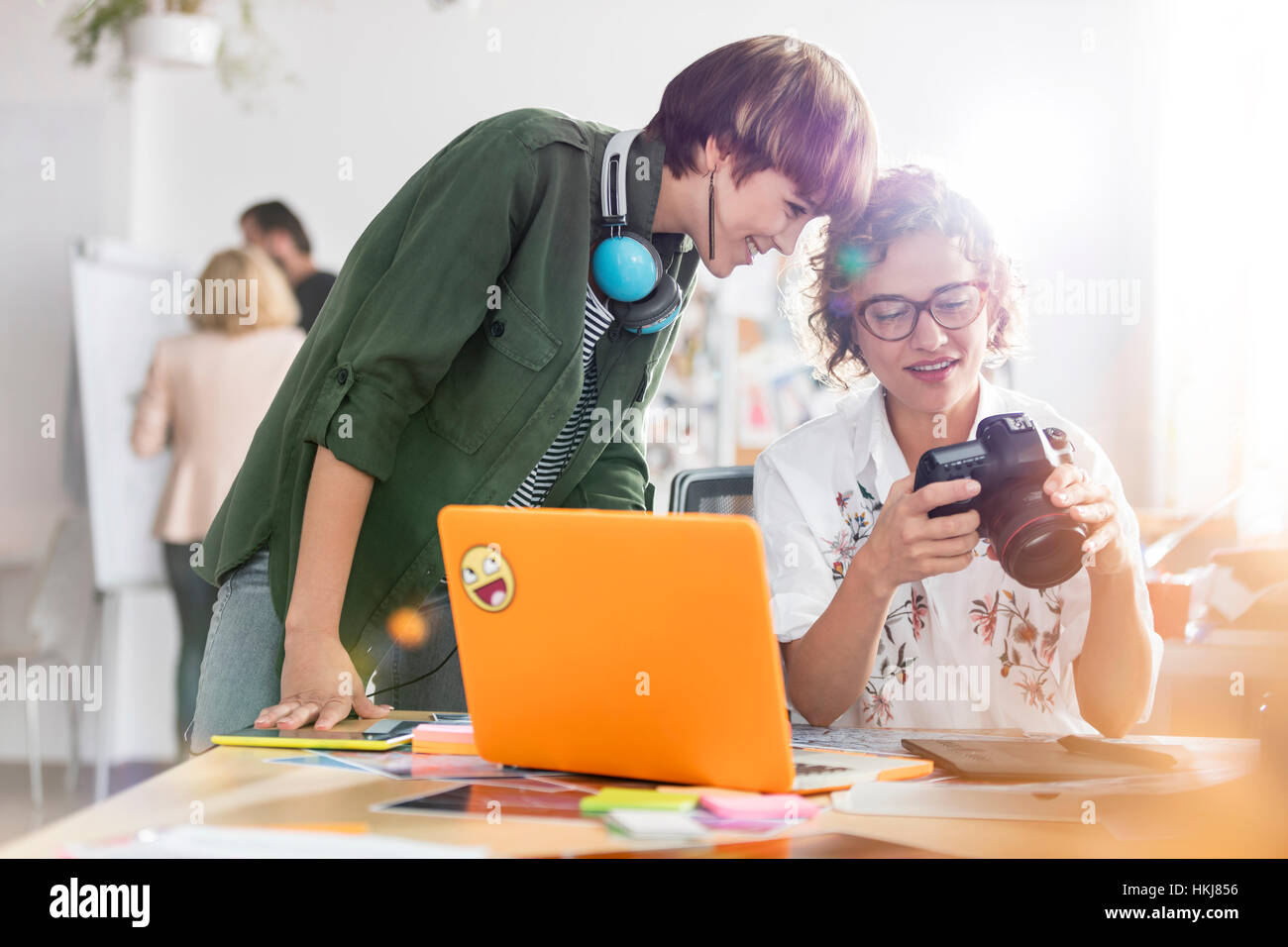 Photographer design professionals with SLR camera at laptop Stock Photo