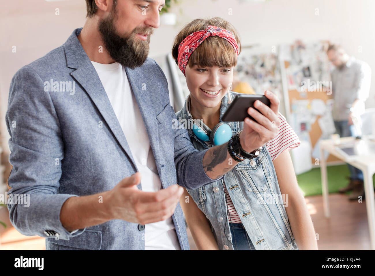 Design professionals using cell phone in office Stock Photo - Alamy