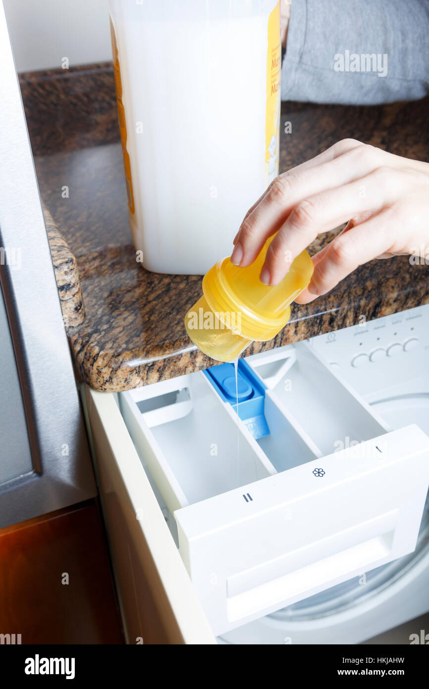 Woman pouring liquid softener into washing machine Stock Photo Alamy