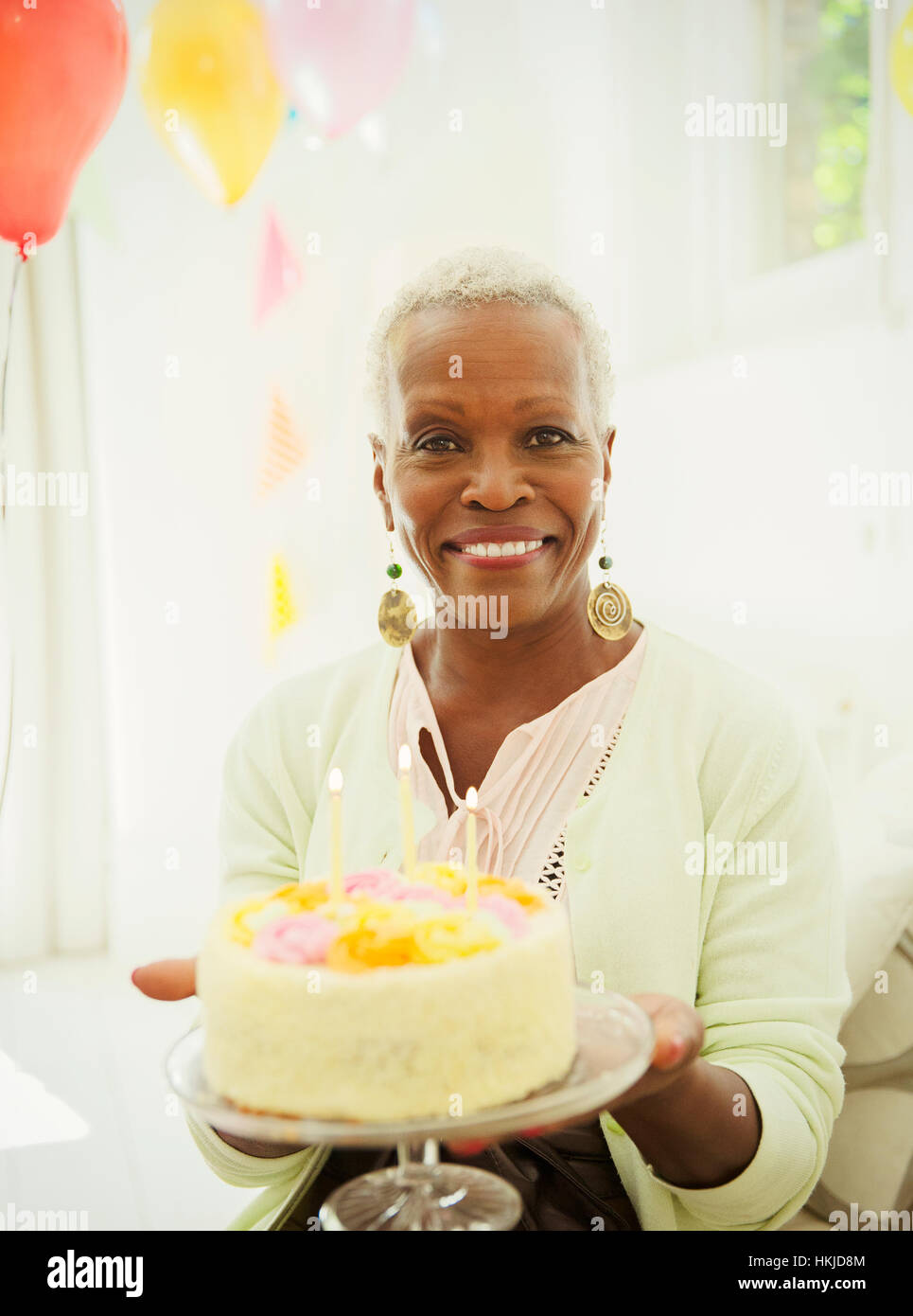 Portrait smiling senior woman holding birthday cake Stock Photo - Alamy