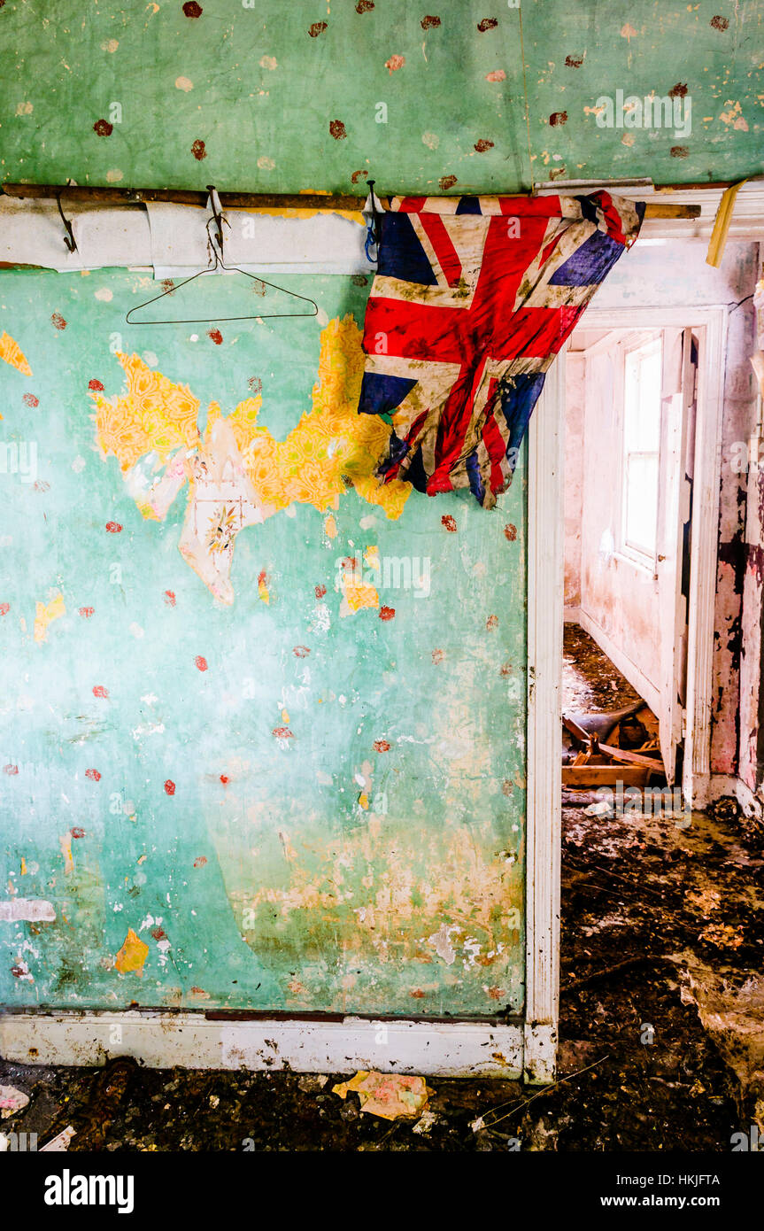 A tattered Union Flag hangs up in an abandoned house. Stock Photo