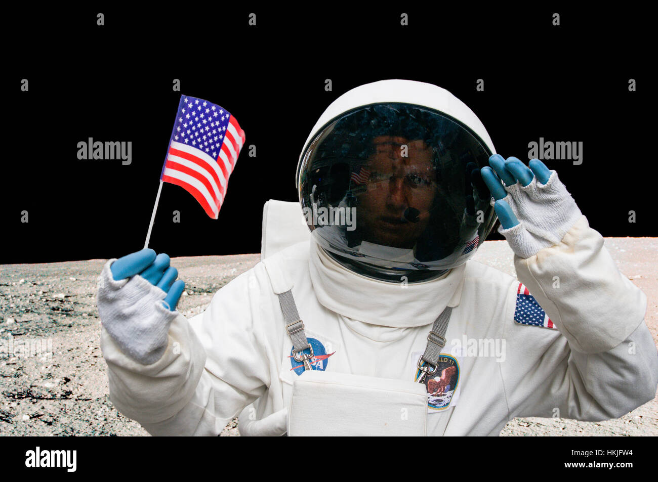 Person dressed as a NASA astronaut holding an American flag on a street. Stock Photo