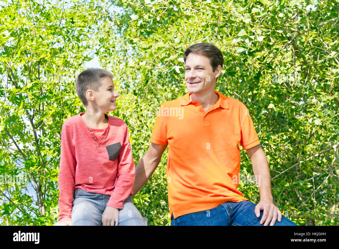 Father and son are talking smiling in summer park Stock Photo