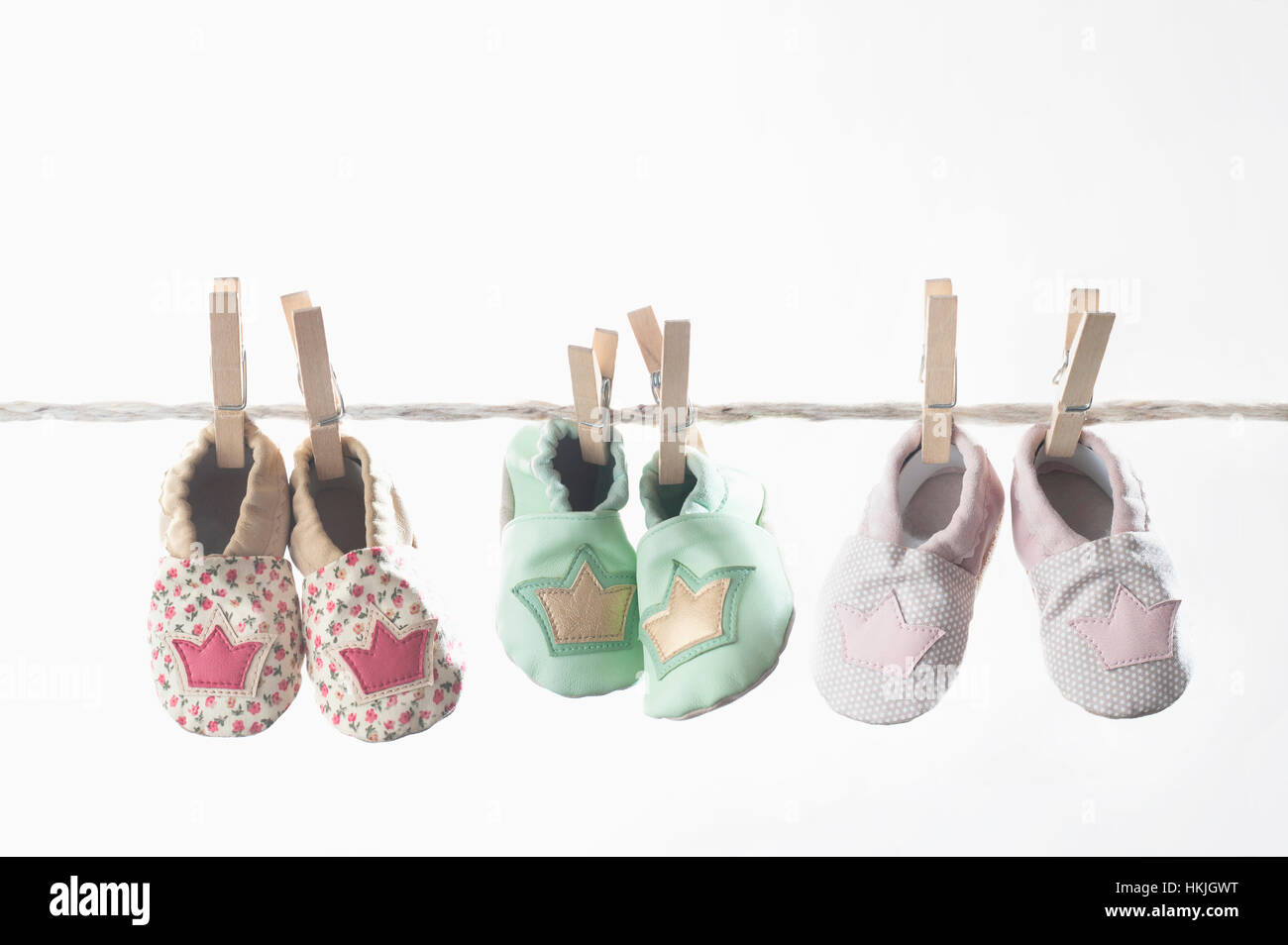 Three pairs of baby shoes hanging on clothes line, Bavaria, Germany Stock Photo
