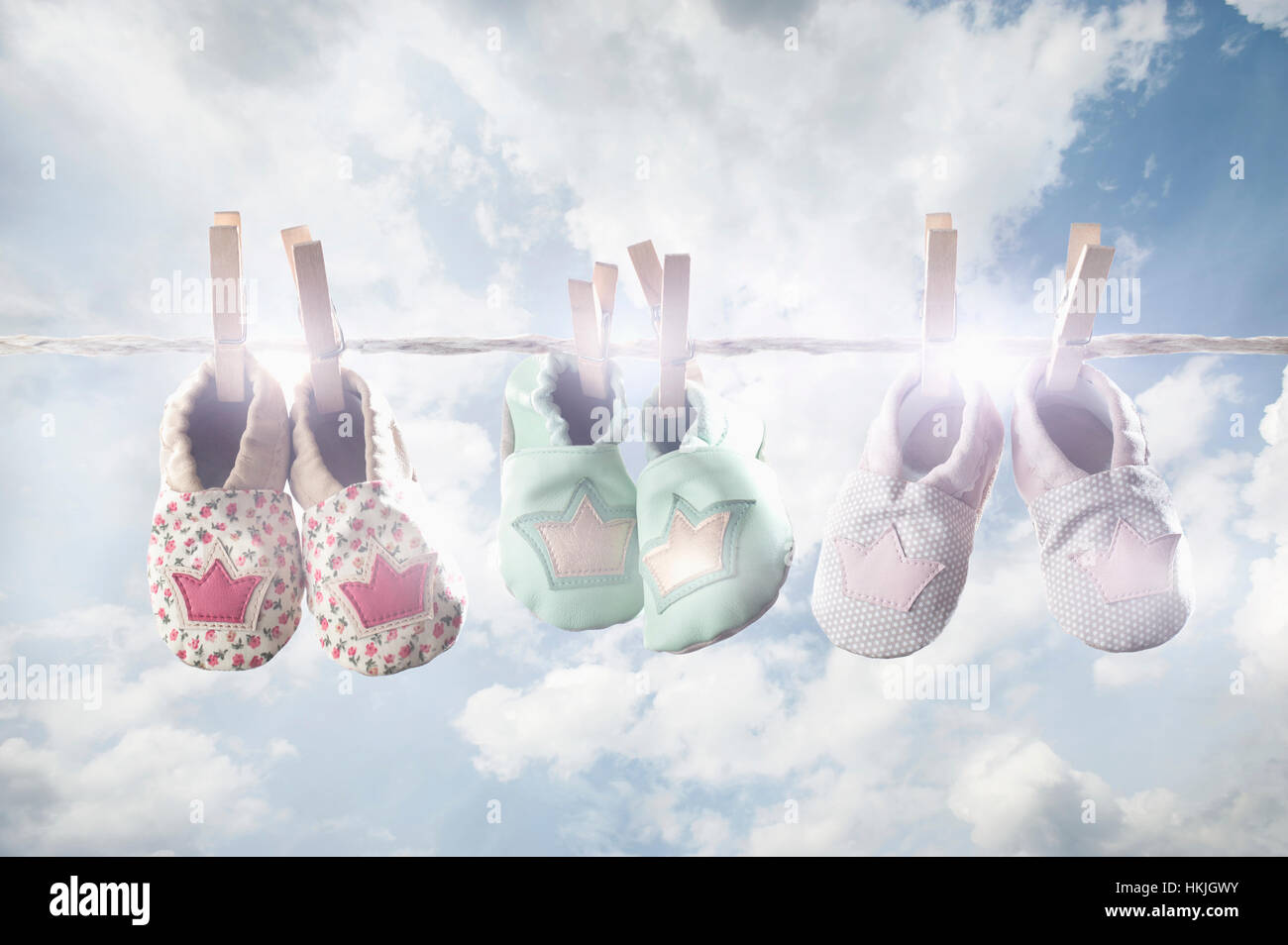 Pair of baby shoes hanging on clothes line, Bavaria, Germany Stock Photo