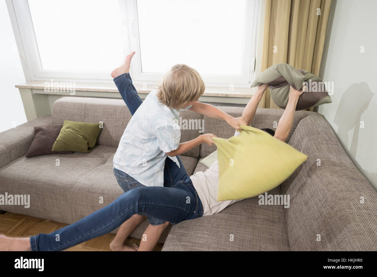 Woman pillow fighting with her son in living room,Bavaria,Germany Stock Photo