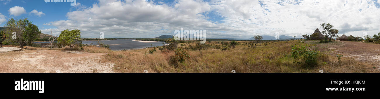Distant view of grass huts and tepui mountain, Canaima National Park, Venezuela Stock Photo