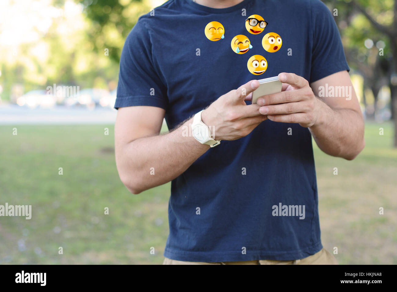 Portrait Of Young Latin Man Typing On His Phone With Emoji Emoticons Emoji And Communication 