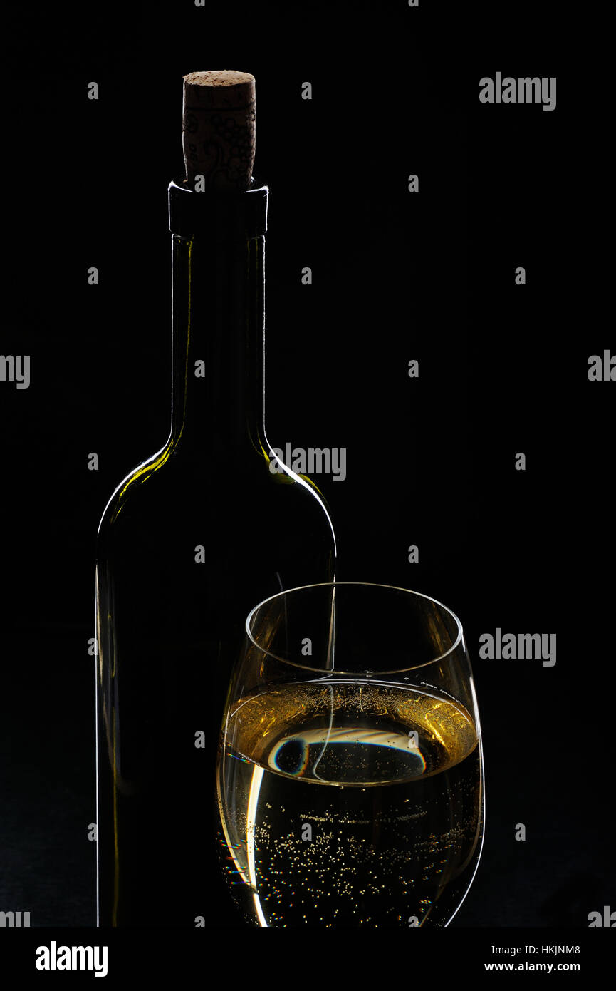 white wine bottle and full glass on black background Stock Photo