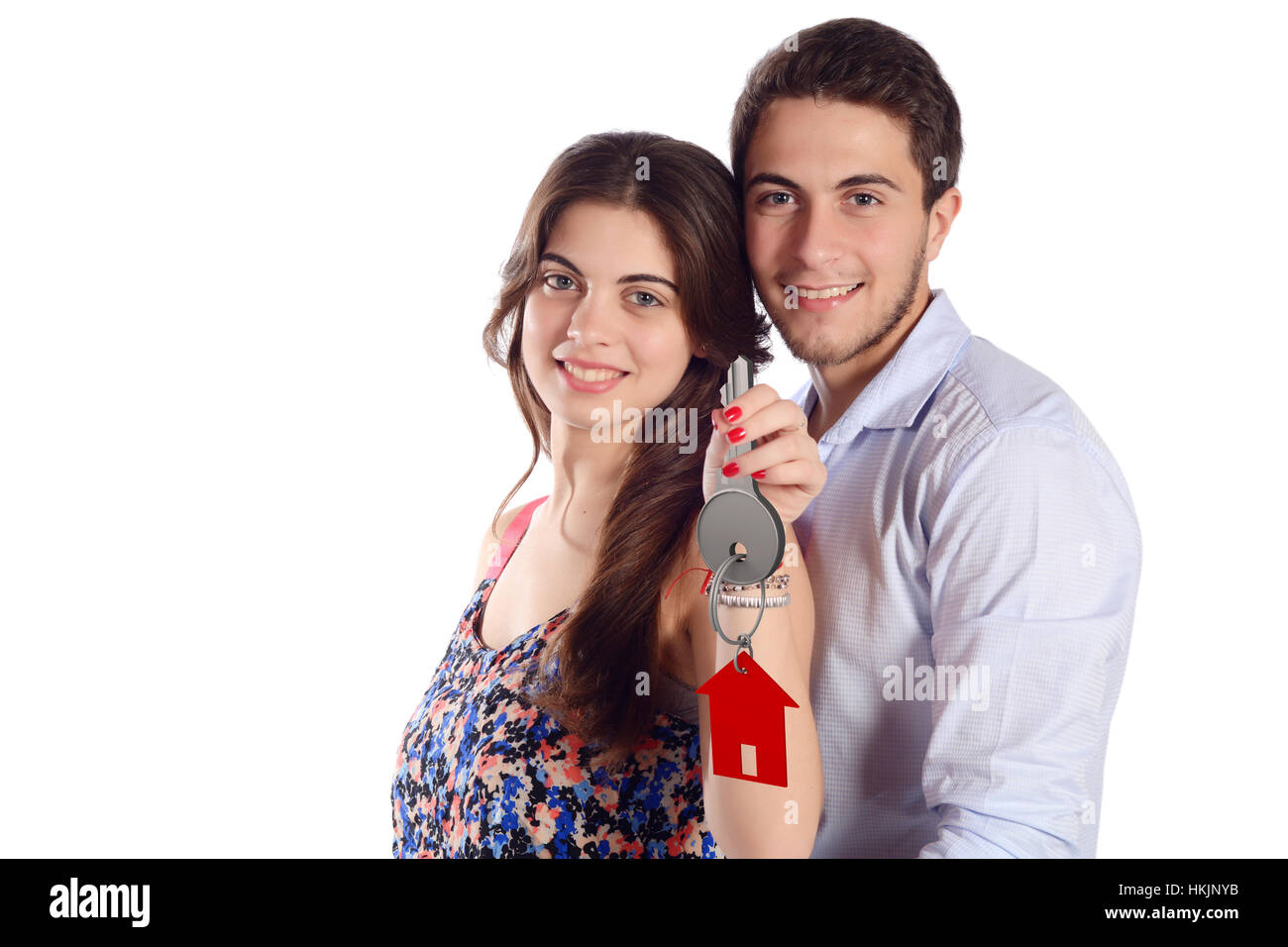 Portrait of a young beautiful couple holding new house keys. Isolated ...
