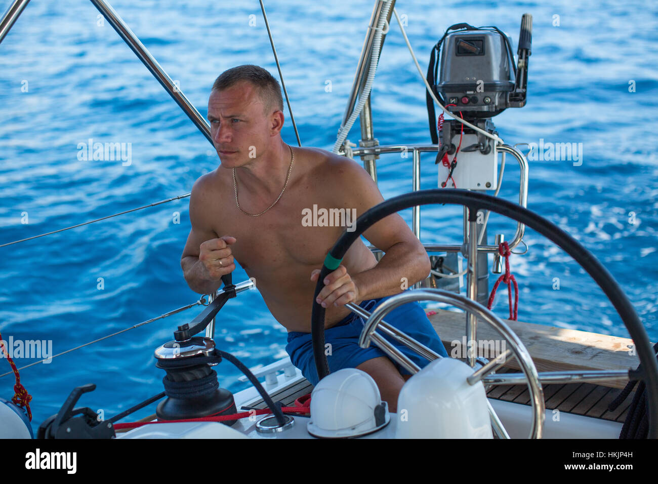 Sailing. Man at the helm sail boat, the ship controls during sea yacht