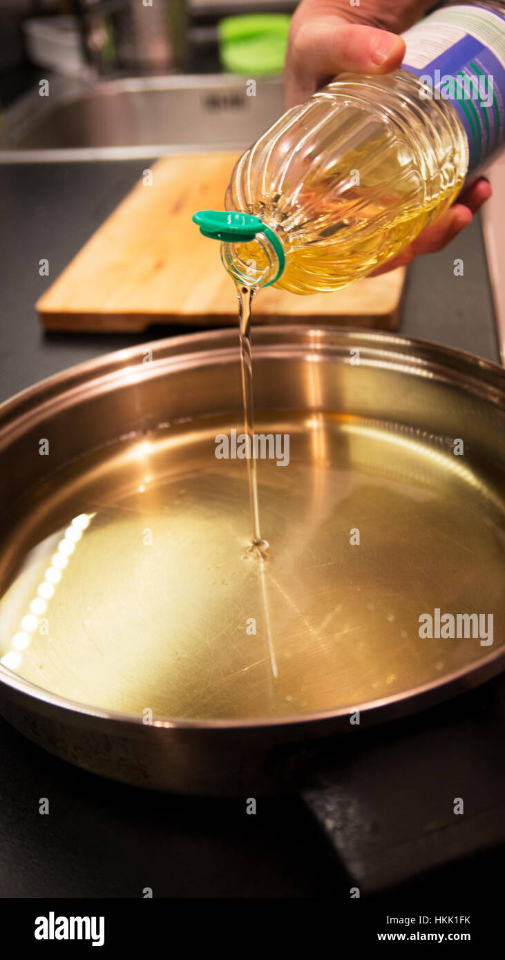 Pouring oil in a frying pan Stock Photo Alamy