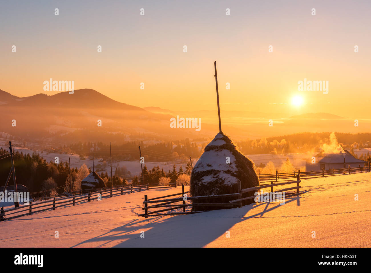 Alone haystack in winter mountains with beauty orange sunrise light Stock Photo