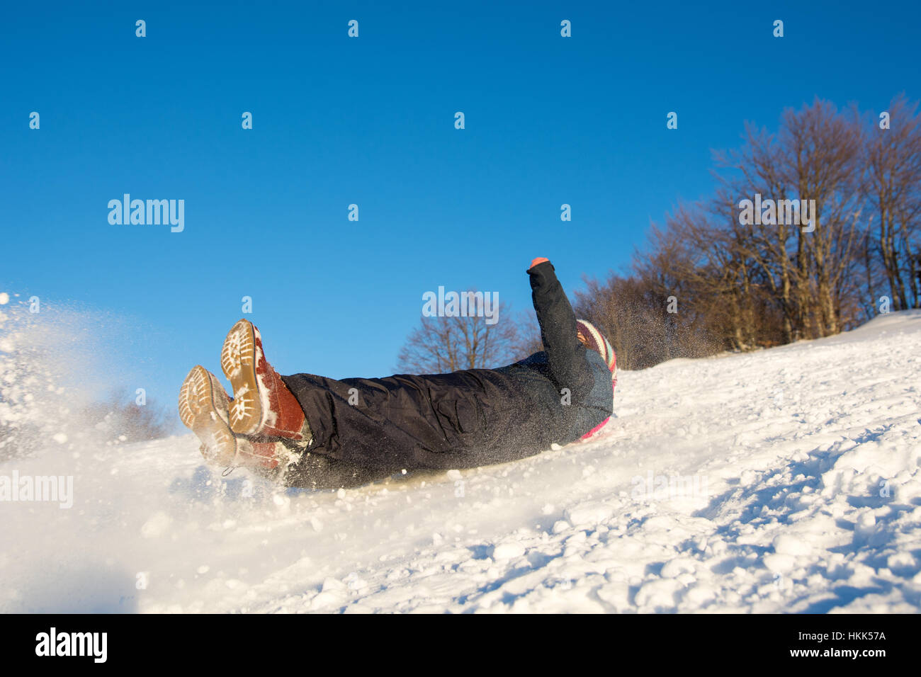 Girl falling down on the snowy mountain Stock Photo