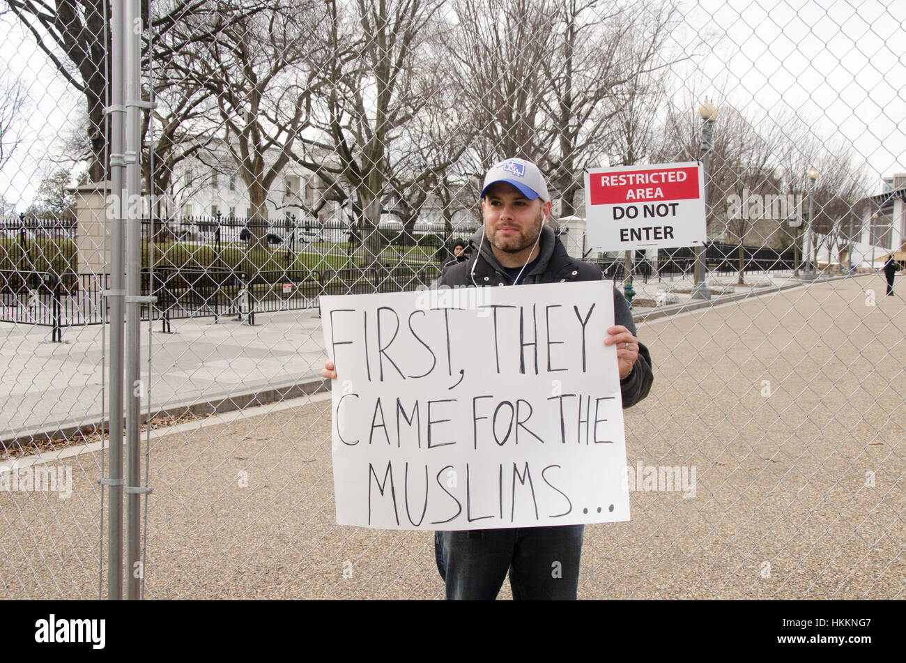 Washington, USA. 29th Jan, 2017. Protester holds sign that reads, 'First, they came for the Muslims' while standing before the White House during a protest opposing Donald Trump's immigration policies and refugee ban, in Washington D.C. Credit: Angela Drake/Alamy Live News Stock Photo