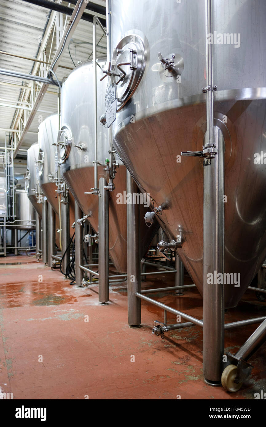 Several stainless steel commercial beer tanks used for fermenting beer at Railway City Brewing Co. in St Thomas, Ontario, Canada. Stock Photo