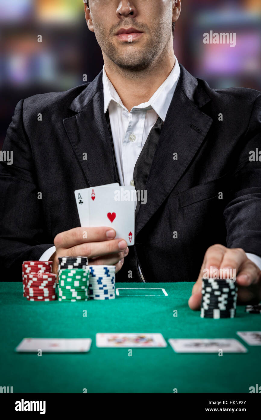 Poker player showing a pair of aces, on a cassino background Stock Photo -  Alamy